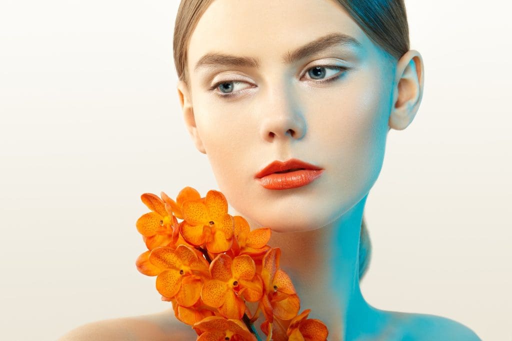 Retrato de mujer joven con flor de forma creativa para transmitir emociones