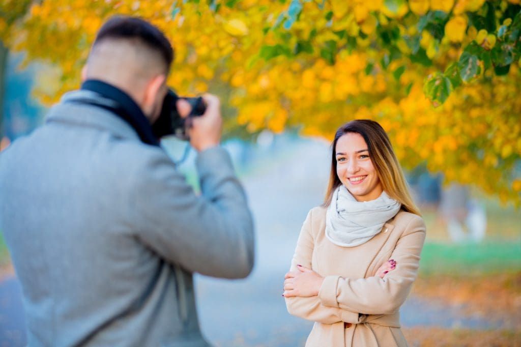 Persona tomando retrato a mujer con cámara profesional